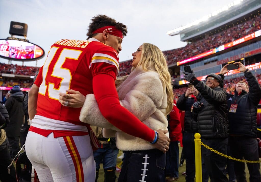 Jan 26, 2025; Kansas City, MO, USA; Kansas City Chiefs quarterback Patrick Mahomes (15) and wife Brittany Mahomes kiss before the AFC Championship game against the Buffalo Bills at GEHA Field at Arrowhead Stadium. Mandatory Credit: Mark J. Rebilas-Imagn Images