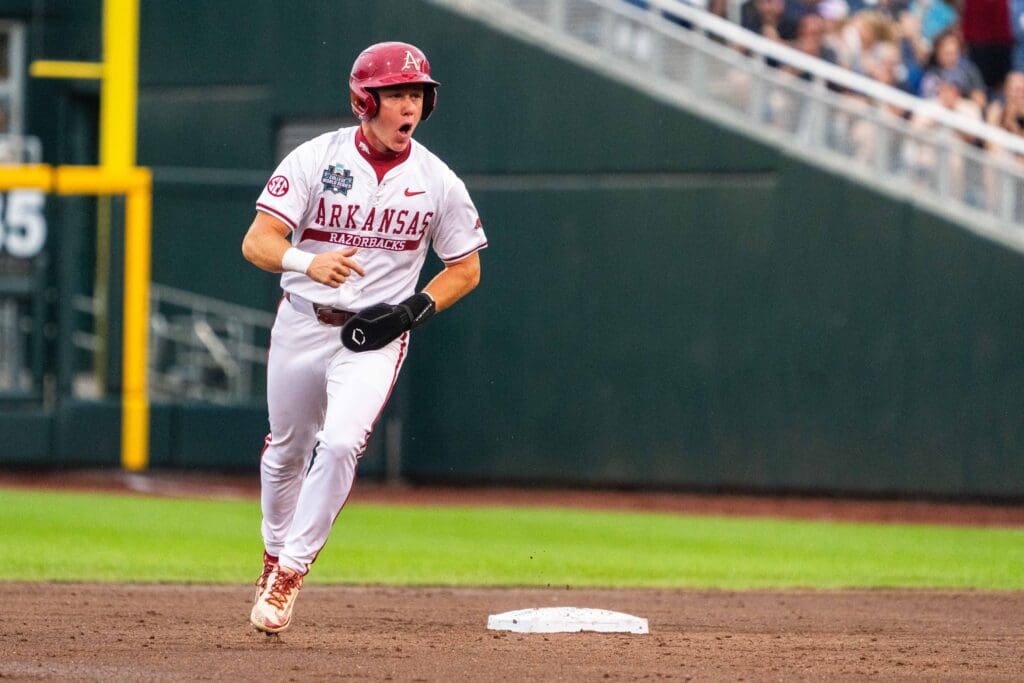 Jun 17, 2025; Omaha, Neb, USA; Arkansas Razorbacks left fielder Charles Davalan (24) celebrates after a two-run home run by shortstop Wehiwa Aloy (9) against the UCLA Bruins during the first inning at Charles Schwab Field. Mandatory Credit: Dylan Widger-Imagn Images