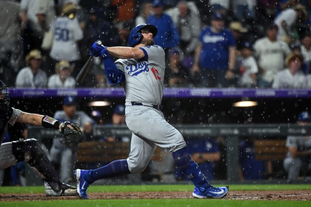 Jun 25, 2025; Denver, Colorado, USA; Los Angeles Dodgers third base Max Muncy (13) hits a two RBI infield single when Colorado Rockies second base Thairo Estrada (not pictured) lost the ball in the rain during the sixth inning at Coors Field. Mandatory Credit: Christopher Hanewinckel-Imagn Images