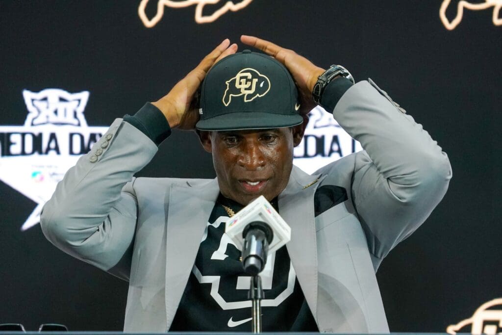 Jul 9, 2025; Frisco, TX, USA; Colorado head coach Deion Sanders fixes his cap prior to speaking with the media during 2025 Big 12 Football Media Days at The Star. Mandatory Credit: Raymond Carlin III-Imagn Images