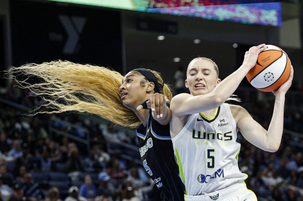 Jul 9, 2025; Chicago, Illinois, USA; Dallas Wings guard Paige Bueckers (5) grabs a rebound against Chicago Sky forward Angel Reese (5) during the second half of a WNBA game at Wintrust Arena. Mandatory Credit: Kamil Krzaczynski-Imagn Images