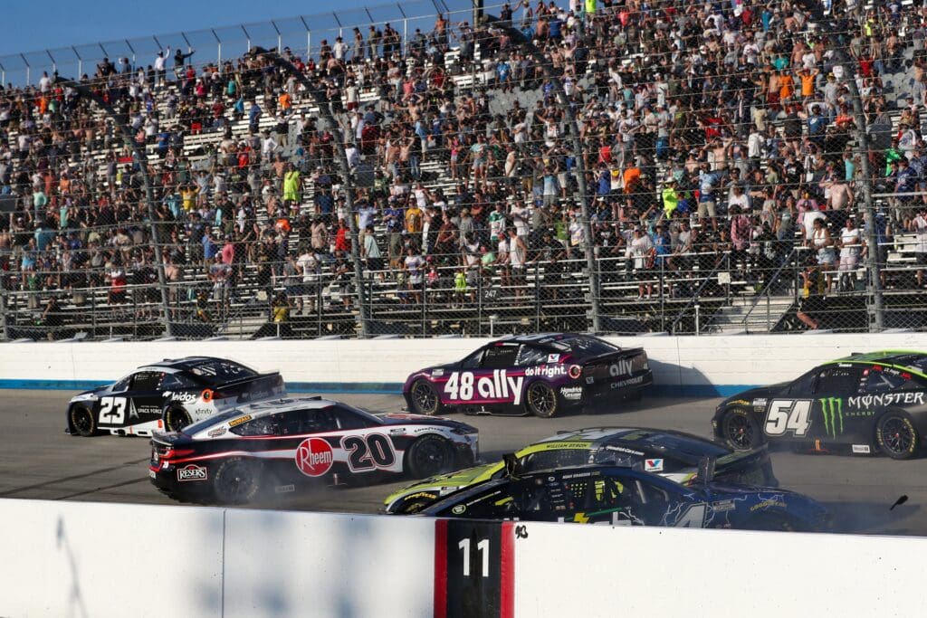 Jul 20, 2025; Dover, Delaware, USA; NASCAR Cup Series driver Christopher Bell (20) spins while collecting driver William Byron (24) and driver Noah Gragson (4) during the Autotrader EchoPark Automotive 400 at Dover Motor Speedway. Mandatory Credit: Matthew O'Haren-Imagn Images