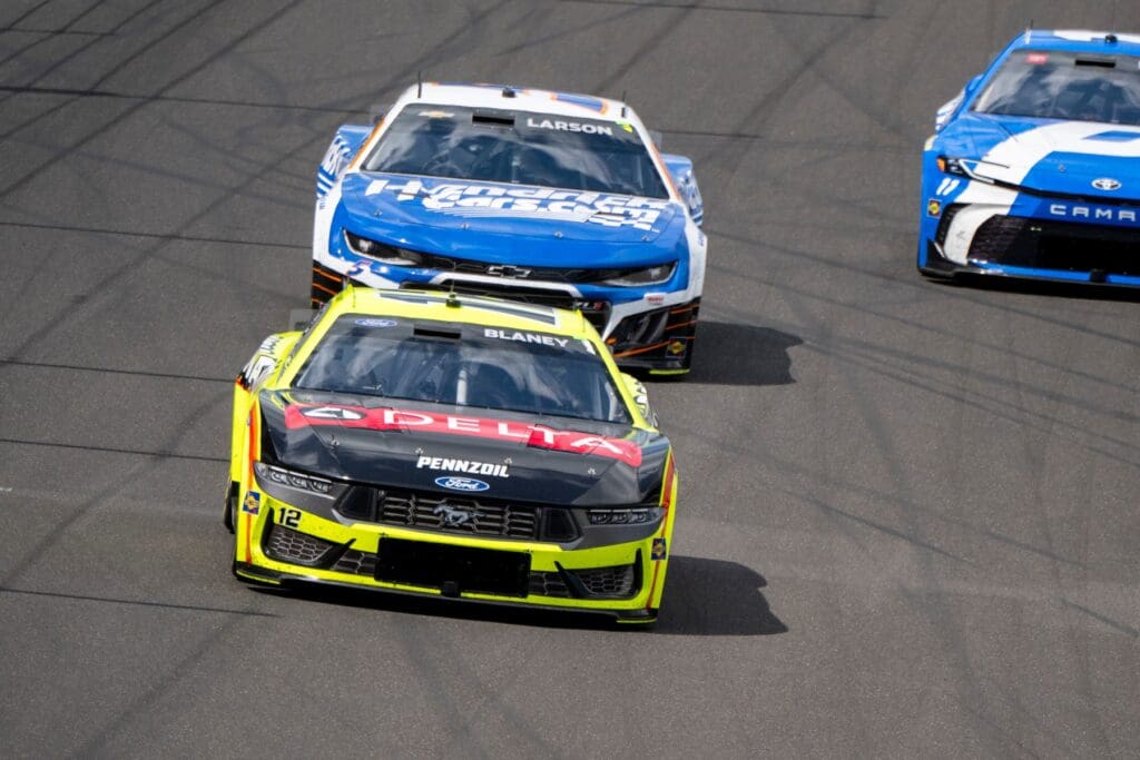 NASCAR Cup Series driver Ryan Blaney (12) coasts into the first turn after taking the green checkered flag to win the second stage of racing Sunday, July 27, 2025, during the Brickyard 400 at Indianapolis Motor Speedway.