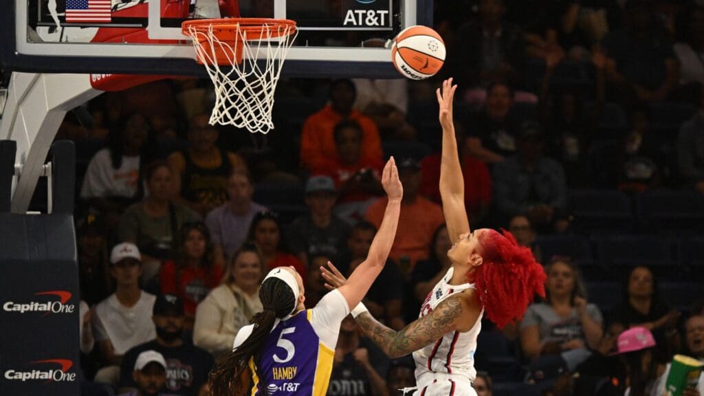 Jul 22, 2025; Washington, District of Columbia, USA; Washington Mystics forward Shakira Austin (0) attempts a lay up in front of Los Angeles Sparks forward Dearica Hamby (5) during the first quarter at CareFirst Arena