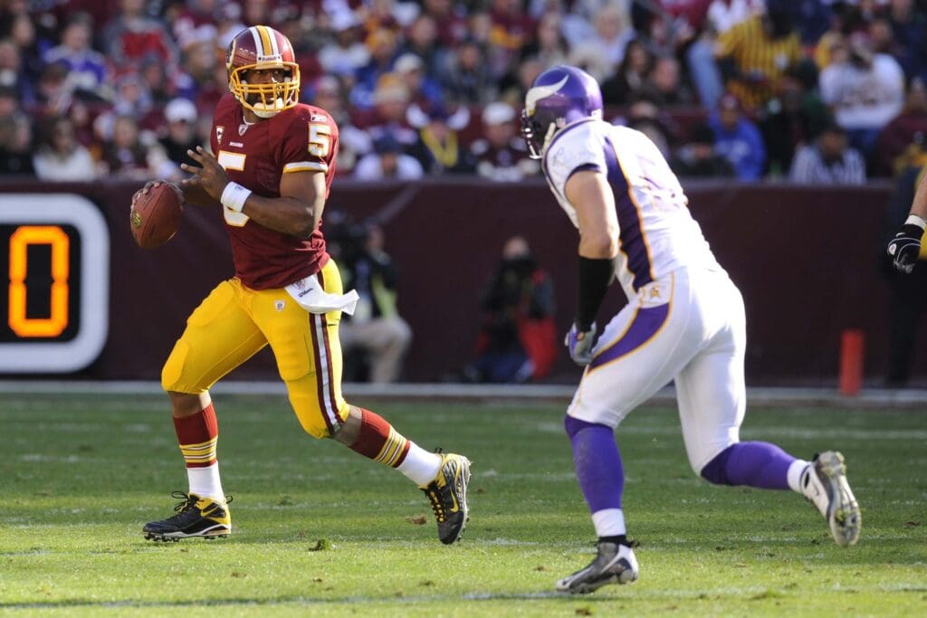 Nov 28, 2010; Landover, MD, USA; Washington Redskins quarterback Donovan McNabb (5) is chased out of the pocket by Minnesota Vikings linebacker Ben Leber (51) during the first half at FedEx Field. 
