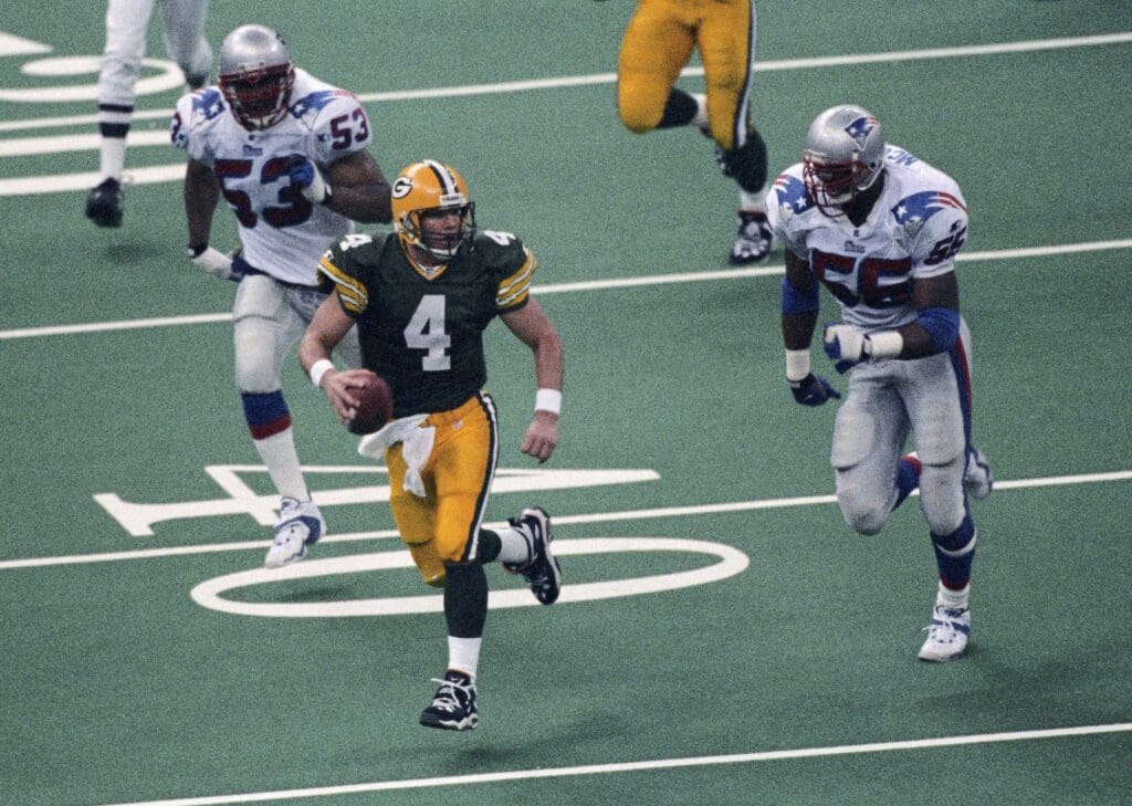 Jan 26, 1997; New Orleans, LA, USA; FILE PHOTO; Green Bay Packers quarterback Brett Favre (4) in action against New England Patriots defensive end Willie McGinest (55) and linebacker Chris Slade (53) during Super Bowl XXXI at the Superdome. Green Bay defeated New England 35-21.