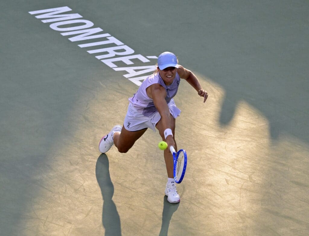 Aug 1, 2025; Montreal, QC, Canada; Iga Swiatek (POL) returns the ball against Eva Lys (GER) in third round play at IGA Stadium. 