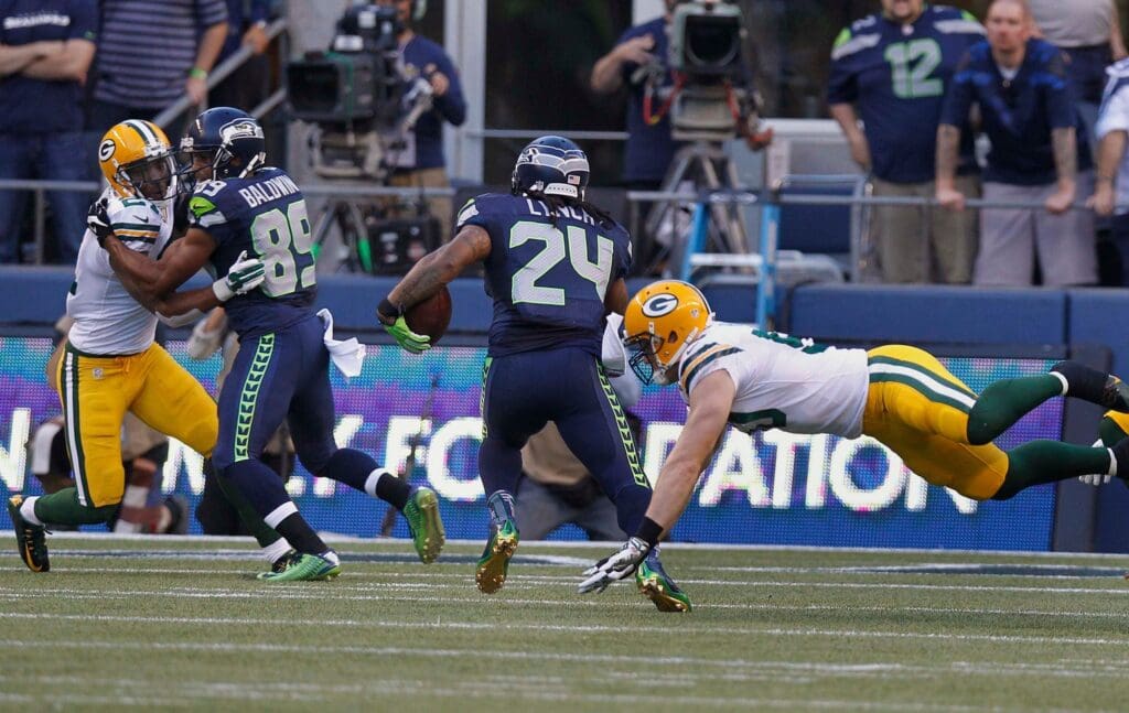 Seattle Seahawks running back Marshawn Lynch (24) scores a touchdown eluding the Packer defense during the Green Bay Packers-Seattle Seahawks NFL football game Thursday, September 4, 2014 at CenturyLink Field in Seattle, Wash.