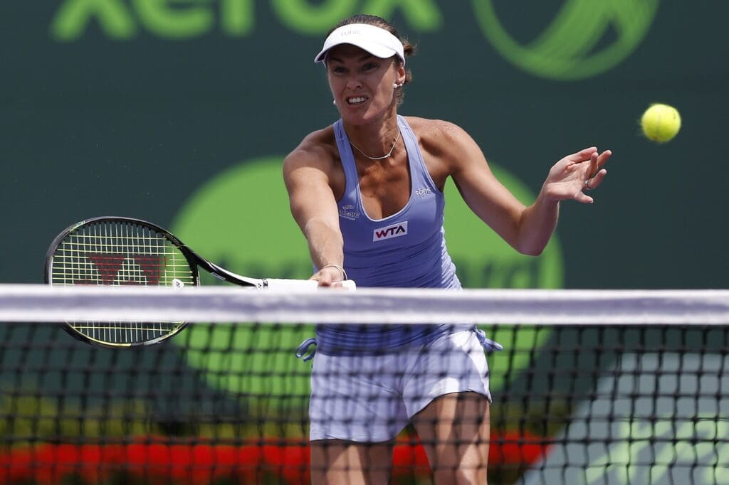 Mar 30, 2014; Miami, FL, USA; Martina Hingis hits a volley next to partner Sabine Lisicki (not pictured) against Ekaterina Makarova and Elena Vesnina (both not pictured) during the women's doubles championship of the Sony Open at Crandon Tennis Center against. Hingis and Lisicki won 4-6, 7-6, 10-5.