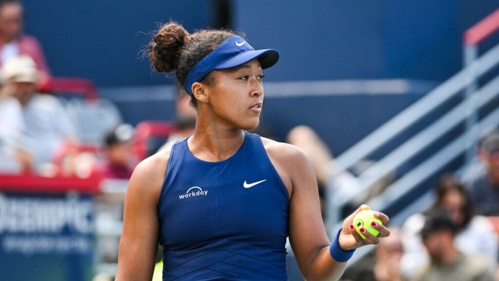 Aug 1, 2025; Montreal, QC, Canada; Naomi Osaka (JPN) gets ready to serve the ball to Jelena Ostapenko (LAT) in third round play at IGA Stadium. 