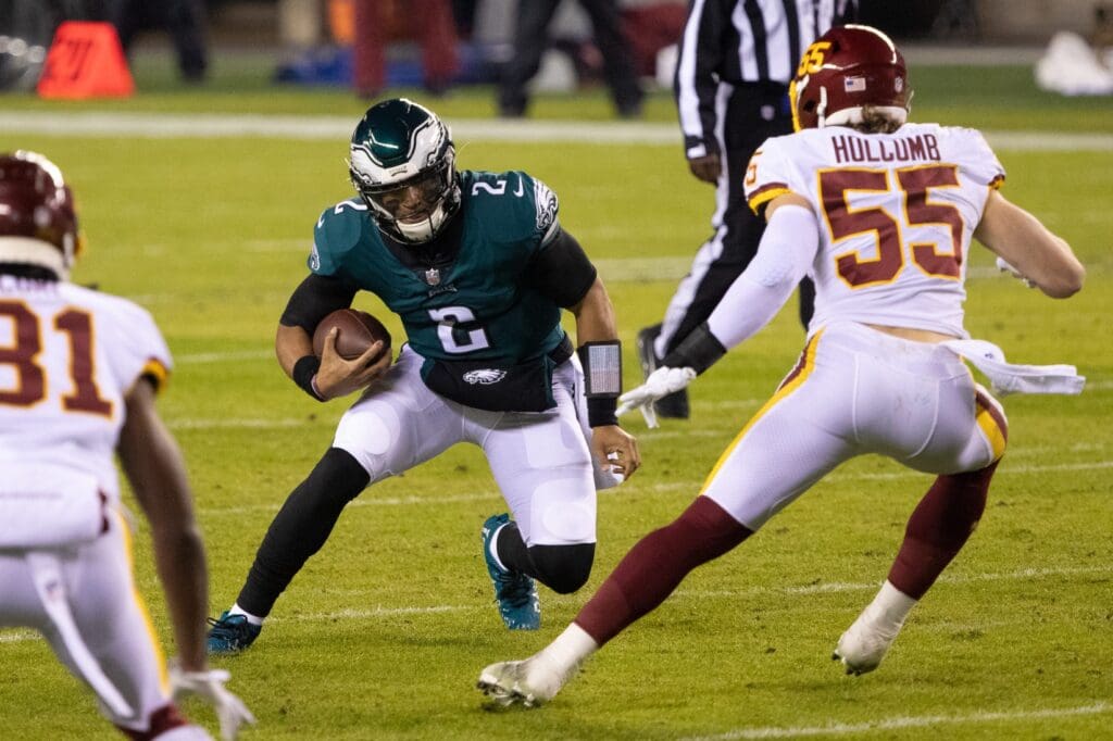 Jan 3, 2021; Philadelphia, Pennsylvania, USA; Philadelphia Eagles quarterback Jalen Hurts (2) runs with the ball against Washington Football Team linebacker Cole Holcomb (55) during the second quarter at Lincoln Financial Field.