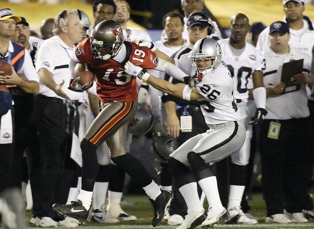 Jan 26, 2003; San Diego, CA, USA; FILE PHOTO; Tamp Bay Buccaneers receiver Keyshawn Johnson (19) carries the ball as Oakland Raiders defensive back Rod Woodson (26) grabs him along the sideline during Super Bowl XXXVII at Qualcomm Stadium. The Bucs defeated the Raiders 48-21.
