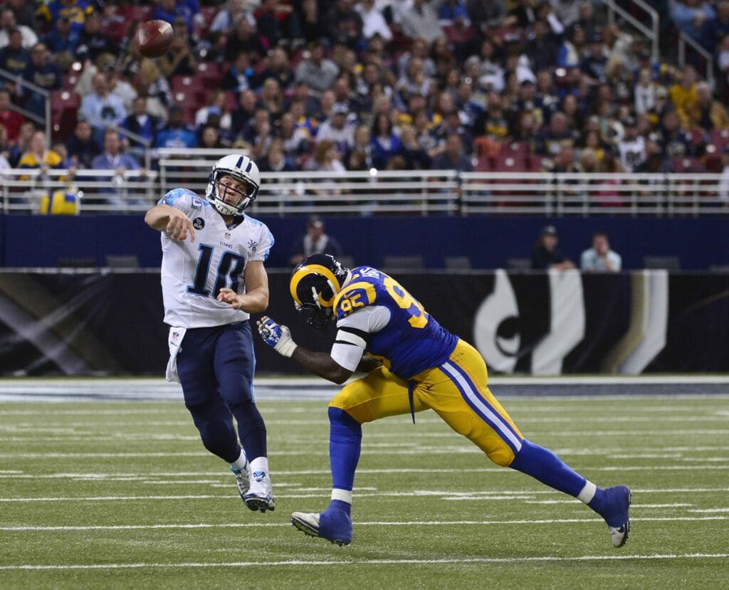 Nov 3, 2013; St. Louis, MO, USA; Tennessee Titans quarterback Jake Locker (10) attempts a pass as St. Louis Rams defensive end William Hayes (95) pressures during the second half at the Edward Jones Dome. The Titans defeated the Rams 28-21. 