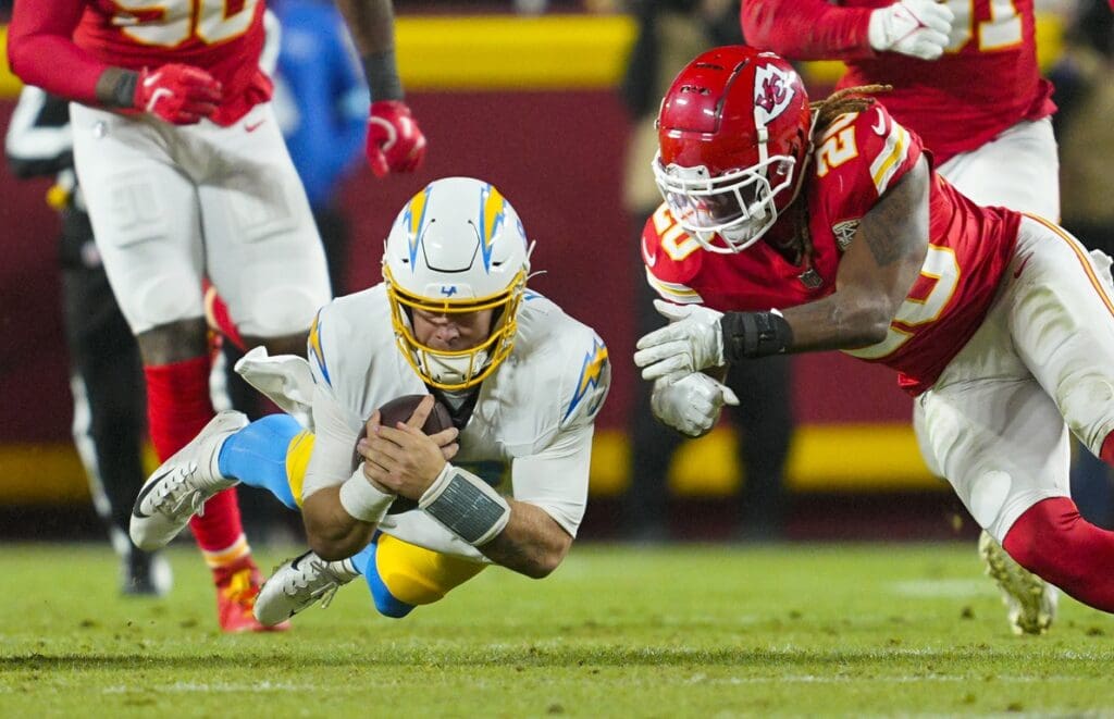 Dec 8, 2024; Kansas City, Missouri, USA; Los Angeles Chargers quarterback Taylor Heinicke (8) dives forward against Kansas City Chiefs safety Justin Reid (20) during the first half at GEHA Field at Arrowhead Stadium. Mandatory Credit: Jay Biggerstaff-Imagn Images